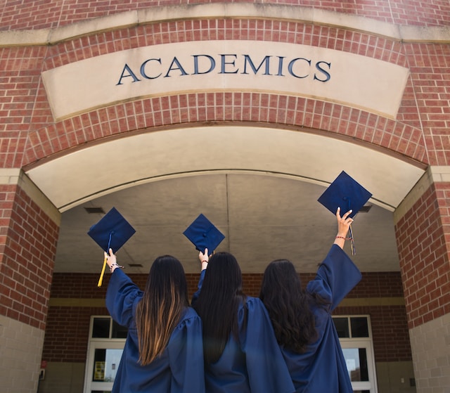 graduates standing in front of academic building